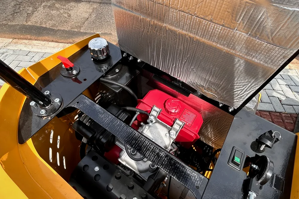 Foto do compartimento do motor da KX10 aberto, sob o assento.